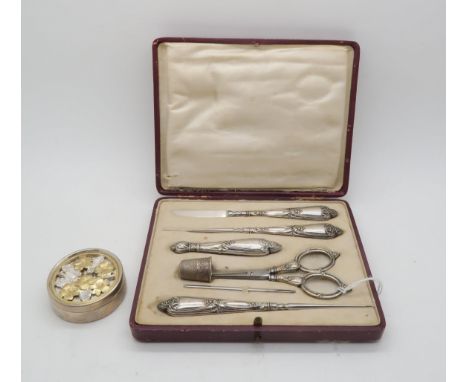 A French white metal art nouveau style sewing set, comprising scissors, needle, seam cutter, and other tools, the handles dec