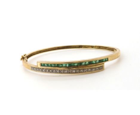 A 9ct emerald and diamond bangle, inner diameter 6cm x 5cm, weight 9.4gms Condition Report:Available upon request