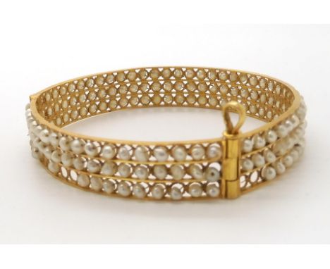 A bright yellow metal bangle with 'wired on' freshwater pearls. Inner diameter 6cm, width 1.2cm, weight 19.9gms Condition Rep