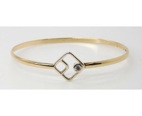A 9ct gold sprung clasp, bangle set with a 0.10ct diamond, inner diameter 6.3cm x 5.5cm, weight 8.9gms Condition Report:Avail