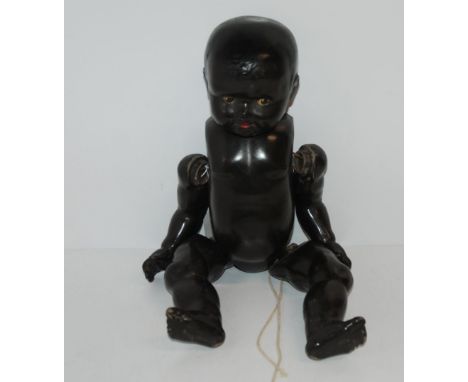 A vintage black doll with open and closed eyes and painted features, 50cm long Condition Report:Available upon request