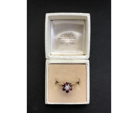 A 9ct gold ring with Rubies and Opal Centre Stone. Total Weight 1.5 grams (approx.)
