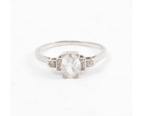 A diamond solitaire ring, the oval old cut diamond four claw set with three small diamonds in each shoulder, shank marked pla