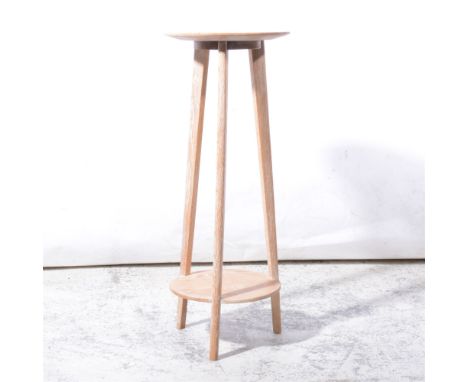 Limed oak two-tier stand, circular top on tripod supports joined by a lower shelf, 30cm diam, height 76cm.