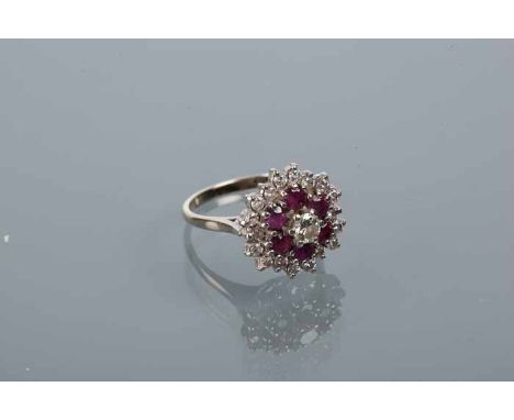 RUBY AND DIAMOND CLUSTER RING
the central brilliant cut diamond approximately 0.25 carats, surround by a rows of rubies and d