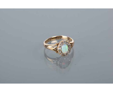 OPAL AND DIAMOND CLUSTER RING
with a central oval cabochon cut opal surrounded by brilliant cut diamonds, hallmarked eighteen