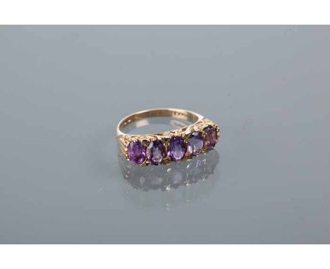 VICTORIAN STYLE AMETHYST FIVE STONE RING
with five oval cut amethysts, in an ornate scrolling setting, in nine carat gold