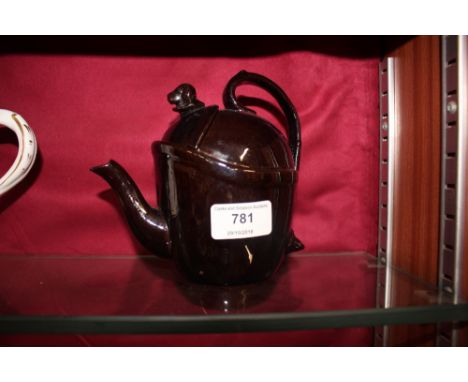 A brown glazed bachelors tea pot with dogs head finial 