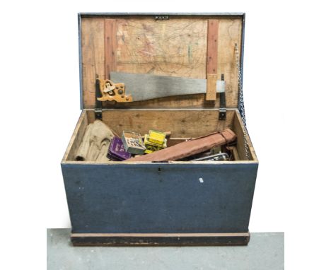 Stained pine trunk, and various hand tools.