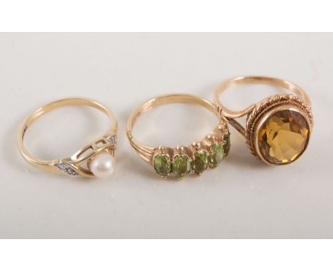 Three dress rings, a 9 carat yellow gold five stone peridot half hoop ring size K, an oval citrine ring size J, a 4.8mm cultu