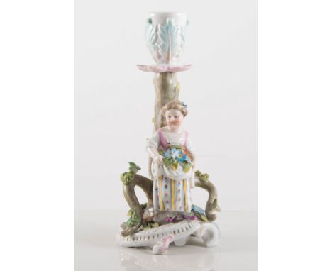 Continental figural salt group, modelled as a boy and girl courting, 10cm. together with a Meissen candlestick (2)
