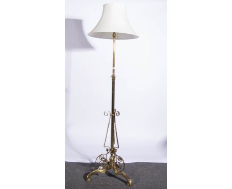 Edwardian brass standard lamp, scrolled tripod base, adjustable column, with shade, current height 180cm.