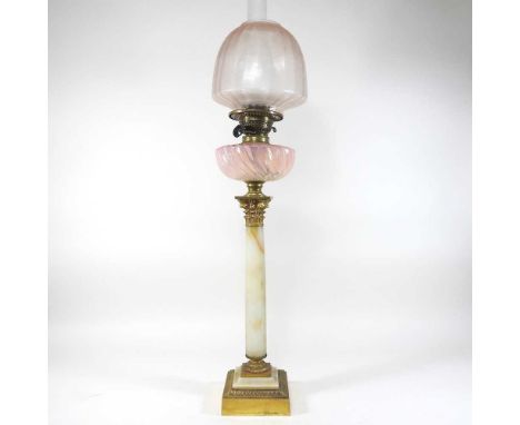 An early 20th century onyx alabaster oil lamp, in the form of a column, with a glass font and etched shade, 80cm high overall