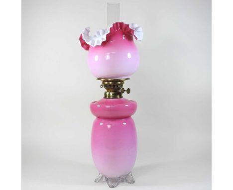 An early 20th century pink glass oil lamp, with a frilled glass shade, 54cm high overall