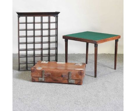 A hardwood hanging wall shelf, 63cm, together with a vintage brown leather suitcase and a folding card table (3)