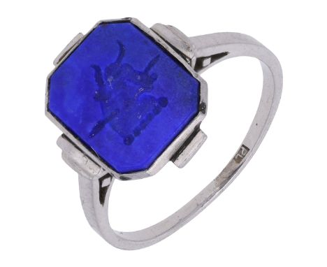 An Art Deco lapis lazuli intaglio ring, circa 1930, the octagonal-shaped plaque carved to depict a bull’s head transfixed by 