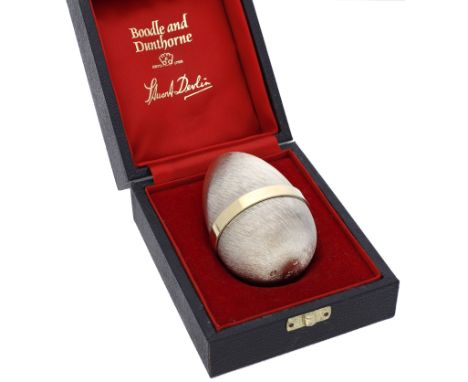 A silver gilt ‘Surprise’ egg by Stuart Devlin, the two section egg with brushed finish and polished collar, opening to reveal