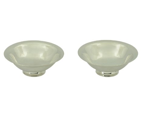A matched pair of Danish silver footed dishes by Georg Jensen, of shallow flared design, raised on circular foot, the first b
