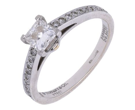 A diamond ring by Tiffany & Co., set with a square-cut diamond, weighing 0.54 carat, between shoulders set with brilliant-cut