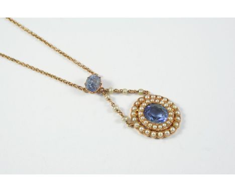 AN EARLY 20TH CENTURY SAPPHIRE AND PEARL CLUSTER PENDANT the oval-shaped sapphire is set within a double surround of half pea