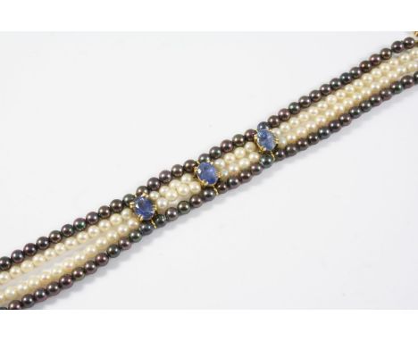 A CULTURED PEARL AND SAPPHIRE BRACELET  formed with two rows of cultured pearls mounted with three oval-shaped sapphires with