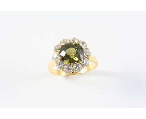 AN ALEXANDRITE AND DIAMOND CLUSTER RING the cushion-shaped alexandrite is set within a surround of ten circular old cut diamo