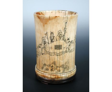 A late 17th/early 18th century ivory brush pot incised with figures playing go on flat rock, lingzhi fungus and bamboo enclos