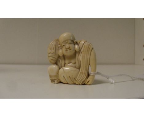 A 19th century ivory netsuke carved as Hotei seated holding the top of his sack over his right shoulder, 4.5cm (1.75 in) high