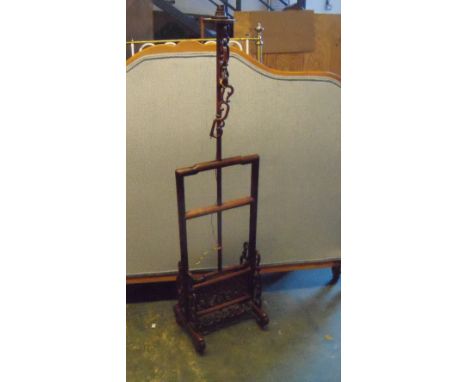 A hardwood hat and robe stand as a lamp, the central column adjustable above the rack below, bars on scroll feet at right ang