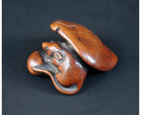 A late 18th/early 19th century wooden mushroom netsuke, the himotoshi at the top of the stalk with a mouse with inlaid eyes n