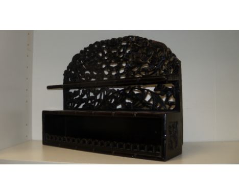 A late 19th/early 20th century zitan wood pipe rack. the bamboo edged upper shelf pierced with six holes before a frieze of t