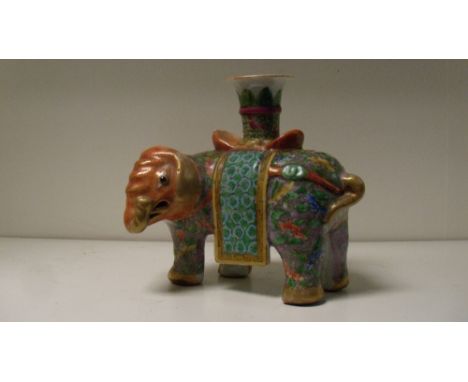 A 19th century Canton elephant candlestick, the pachyderm with orange head and floral stippled purple body, the nozzle on an 