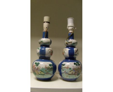 A pair of late 19th/early 20th century famille verte double gourd vases, the triple lobed bodies painted with garden and figu