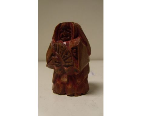 A Nara ningyo ittabori netsuke depicting a Noh actor standing holding a fan, the soft wood painted predominantly red, 5.5cm (