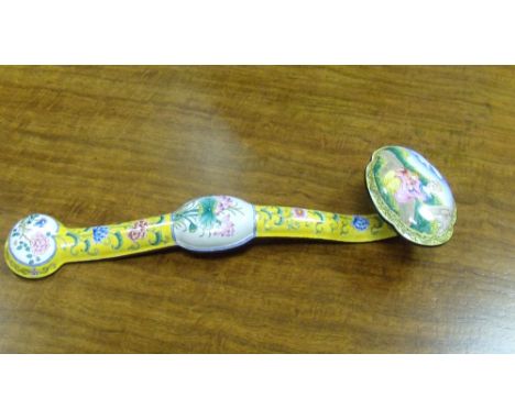 An enamel ruyi sceptre, the quatrefoil head painted with a European mother and child in a garden, the flowers on a yellow gro