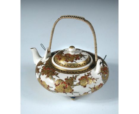 A late 19th/early 20th century Satsuma tea pot and cover, the squat globular body painted with red and gold blossoms flowerin