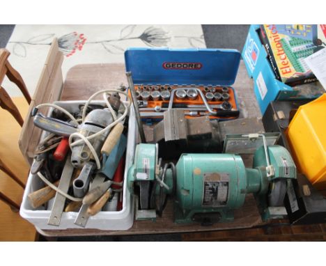 An industrial electric table grinder, a box of tools, large metal clamp