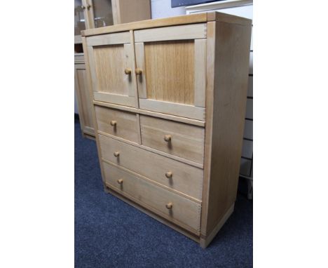 A light oak double door storage cabinet fitted with four drawers 