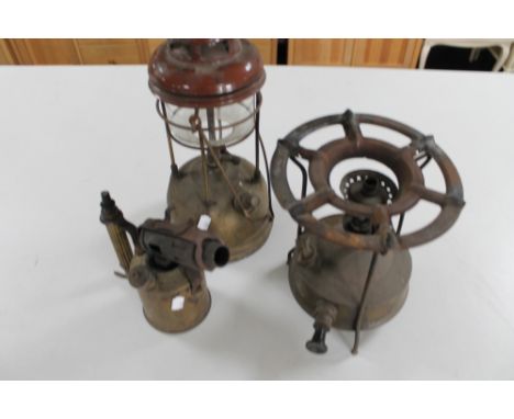 An antique blow torch together with a swing handled lamp and a burner