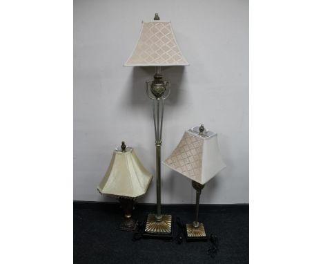 A silvered contemporary standard lamp together with two similar table lamps 