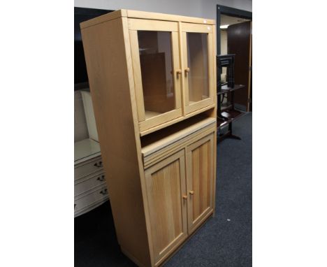 A light oak double door glazed cabinet 