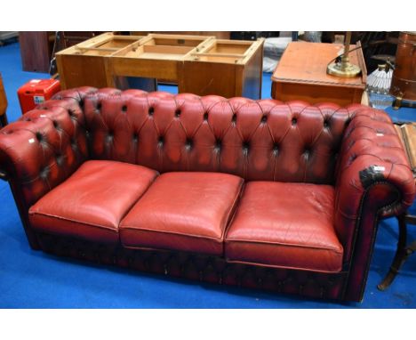 A red leather three seater button back chesterfield settee