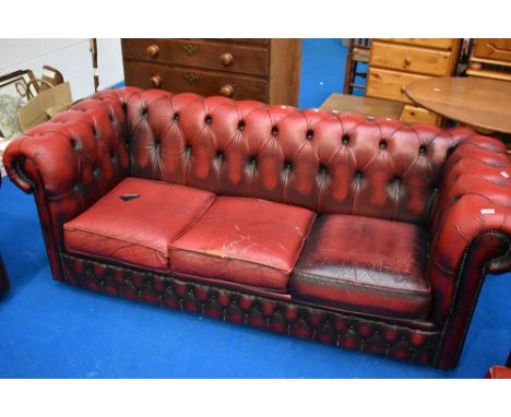 A red leather three seater button back chesterfield settee