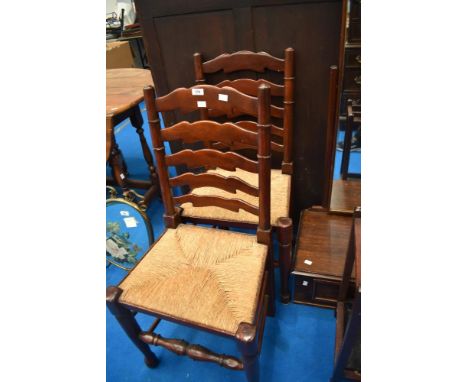 A pair of traditional ladder back chairs having rush seats
