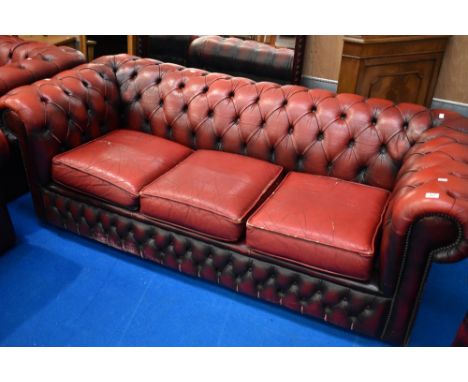 A red leather three seater button back chesterfield settee