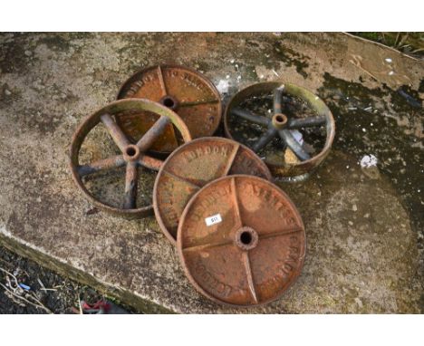 A selection of vintage cast iron wheels, from small cart , trough or similar