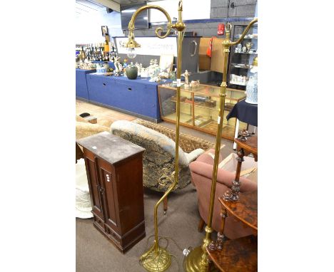 An early 20th Century brass standard lamp in the Arts &amp; Crafts style, scrolled arm and floral embossed base fitted with a