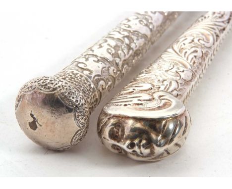 Two Victorian long handled button hooks, one with the handle in the form of a walking cane handle, chased and embossed detail