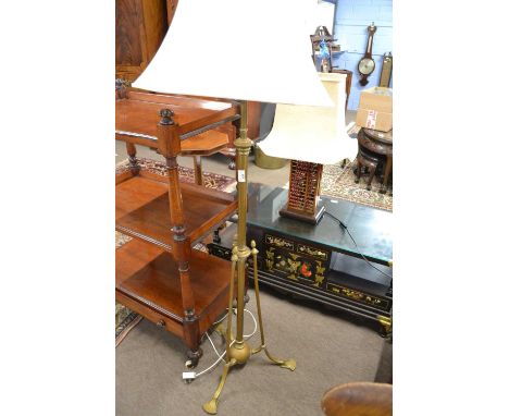 Early 20th Century brass standard lamp raised on three footed base together with cream shade
