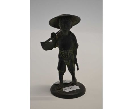 A small bronzed figure of a Chinese workman on circular base, 11cm high, seal mark to base